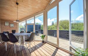 a room with a table and chairs on a deck with windows at Holiday Home Lakolk Xii Denmark in Bolilmark