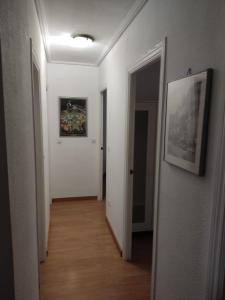 un pasillo con paredes blancas y una foto en la pared en Apartamento de 3 dormitorios y 2 baños, en El Trocadero