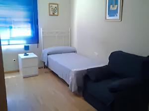 1 dormitorio pequeño con 1 cama y 1 silla en Apartamento de 3 dormitorios y 2 baños, en El Trocadero