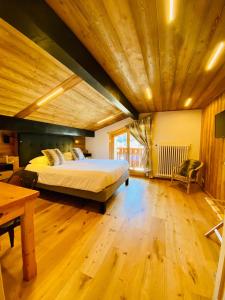 a large bedroom with a bed and a wooden ceiling at Hotel Alpina in Morzine