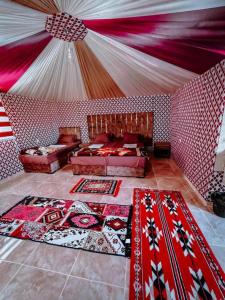 una habitación con una tienda de campaña con alfombras en RUM MAGiC lUXURY CAMP, en Wadi Rum