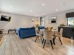 a living room with a blue couch and a table and chairs at 2 Bed in Heyope 94202 in Knighton