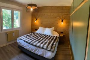 a bedroom with a bed and a wooden wall at Le Barbapou in Ventron