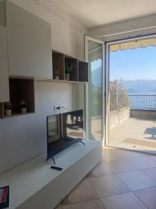 uma sala de estar com uma grande porta de vidro com vista em The Little Eagle - Apartment with Terrace em Argegno