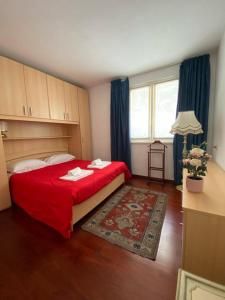 1 dormitorio con cama roja y ventana en The Little Eagle - Apartment with Terrace en Argegno