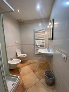 uma casa de banho com 2 lavatórios e um WC em The Little Eagle - Apartment with Terrace em Argegno