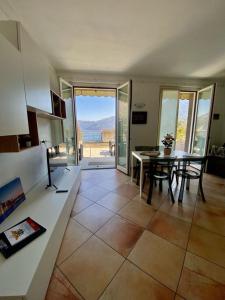 a kitchen with a table and a dining room with a view at The Little Eagle - Apartment with Terrace in Argegno