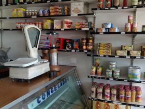 a coffee shop with a counter with food on shelves at El Crucero in La Magdalena