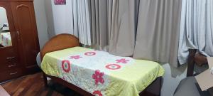 Cette chambre comprend un lit avec une table et des fleurs. dans l'établissement Pousada e Hostel Sossego, à Luminárias