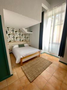 ein Schlafzimmer mit einem Bett und einem großen Fenster in der Unterkunft Le Cloître des Dominicains in Buis-les-Baronnies