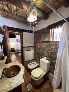 a bathroom with a sink and a toilet and a chandelier at Antigua Tilcara in Tilcara +76 photos