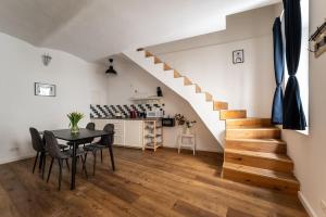 ein Esszimmer mit einem Tisch und einer Treppe in der Unterkunft HM • Cozy 1BR Duplex Near Center in Wien