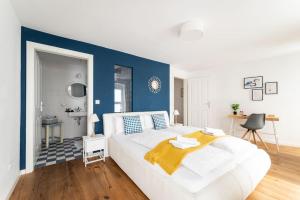 uma cama branca num quarto com uma parede azul em HM • Cozy 1BR Duplex Near Center em Viena