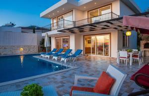 a villa with a swimming pool and chairs and a house at Villa Eslem in Kas