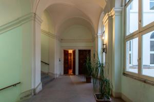 an empty hallway in a building with windows and plants at Maggiore Suite in Perugia
