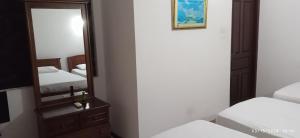 a mirror and a dresser in a bedroom with two beds at Vino Villa Tourists & Local Accommodations - 24 Hrs in Kandy