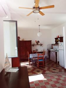 a kitchen with a table and a ceiling fan at Casa Angioletta in Taormina