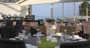a dining room with tables and chairs and windows at Alesha Suite Otel in Trabzon