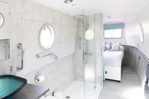 a bathroom with a shower and a sink and a bed at The Jubilee Narrow Boat in Loughborough