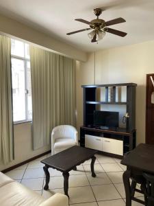 Una sala de estar con un sofá y un televisor. en Manga Rosa Suites, en Salvador