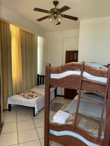 1 dormitorio con 2 literas y ventilador de techo en Manga Rosa Suites, en Salvador