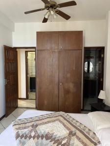 a bedroom with a ceiling fan and a closet at Manga Rosa Suites in Salvador