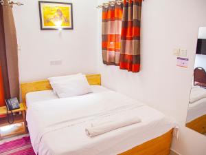 a bedroom with a bed with two towels on it at Explorers Hub in Kampala