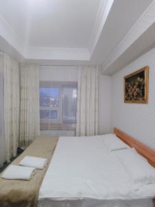 a bedroom with a large bed and a window at Altyn-Adam Hotel in Astana
