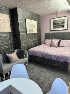 a bedroom with a bed and a couch and a chair at On The Beach Apartments in Blackpool