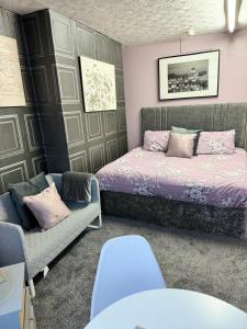 a bedroom with a bed and a couch at On The Beach Apartments in Blackpool