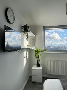 a white room with a clock and a window at City Centre Luxury 2 Bed Apartment Free Parking in Liverpool