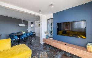 a living room with a large flat screen tv on a blue wall at Gorgeous Home In Novalja With Wifi in Novalja