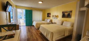 a hotel room with two beds and a balcony at The Savannah Inn in Carolina Beach