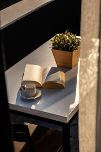 Verde Mare Hotels في أنطاليا: طاولة مع كتاب مفتوح وكوب من القهوة والنبات