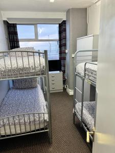 a dorm room with two bunk beds and a window at On The Beach Apartments in Blackpool
