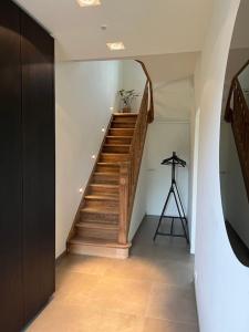 un couloir avec un escalier en bois et un trépied dans l'établissement Gezellig huis met open haard en fenomenale tuin, à Coxyde