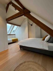 - une chambre mansardée avec un grand lit dans l'établissement Gezellig huis met open haard en fenomenale tuin, à Coxyde