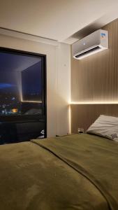 1 dormitorio con 1 cama y ventana grande en Flat em Bananeiras - PB, en Bananeiras