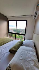 1 dormitorio con 2 camas y ventana grande en Flat em Bananeiras - PB, en Bananeiras