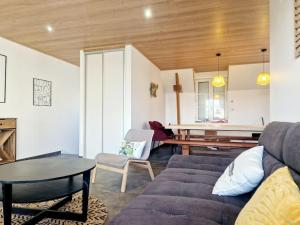 a living room with a couch and a table at Le Cap Ouest in Barneville-Carteret