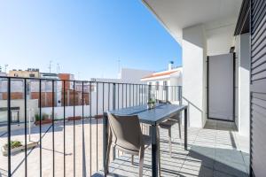 a patio with a table and chairs on a balcony at Hauzify I Apartaments Voramar in San Pol de Mar