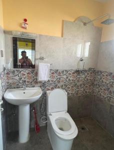 a bathroom with a white toilet and a sink at Hotel Village View Nagarkot in Nagarkot