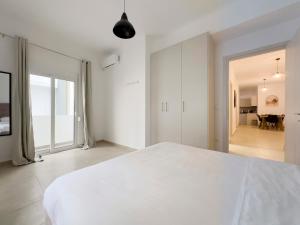 a white bedroom with a large bed and a hallway at Glenvar Heights A2 Spacious apt in Paleo Faliro in Athens