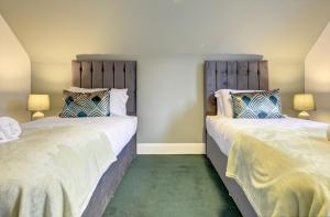 two beds sitting next to each other in a bedroom at Spacious, Luxurious Cliffes in Leicester