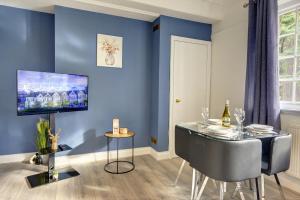 a dining room with a table and a blue wall at Spacious, Luxurious Cliffes in Leicester