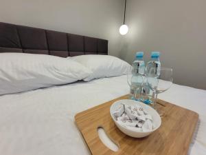 bandeja con dos botellas y vasos en una cama en Dream Rent Apartament Superior, en Łódź