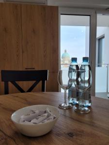 una mesa con dos copas de vino y un tazón en ella en Dream Rent Apartament Superior, en Łódź