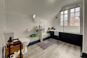 a white bathroom with a sink and a toilet at Spacious, Luxurious Cliffes in Leicester