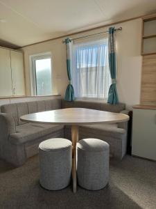 a living room with a table and two chairs at Beautiful 3 bed Caravan in Felixstowe in Felixstowe