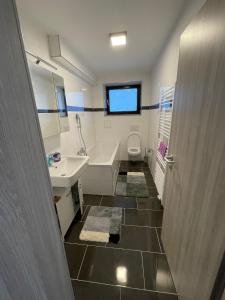 a bathroom with a tub and a sink and a toilet at Luis Zimmer Wohnung Rüsselsheim O1 in Haßloch